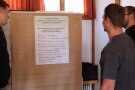 Personen schauen auf ein Plakat