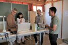 4 Personen stehen um einen Tisch